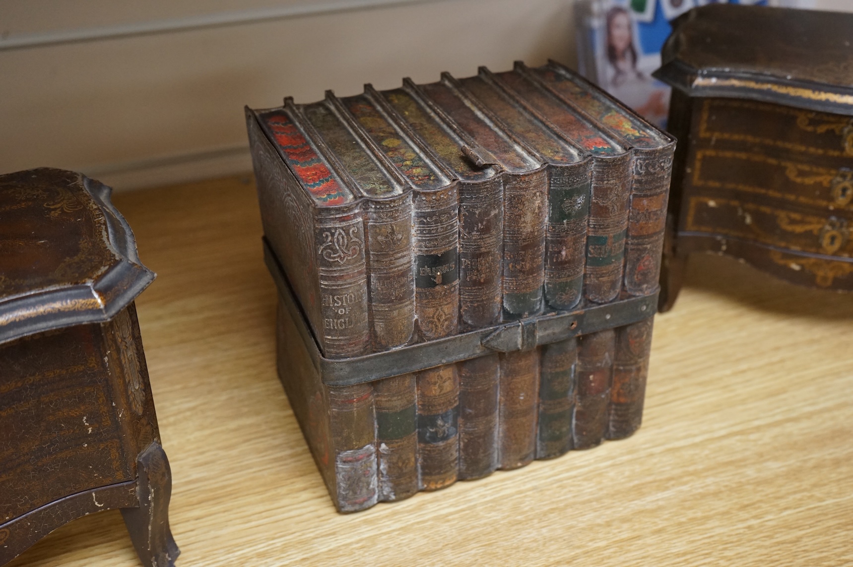 A Huntley and Palmer biscuit tin, modelled as a set of books and and two Mcvitie and Price tins modelled as French chests, tallest 16cm